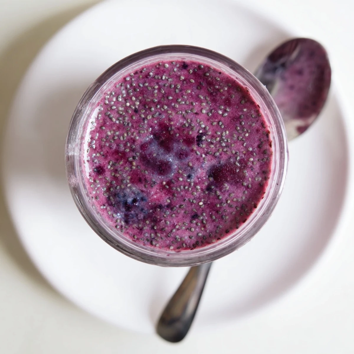 Purple chia seed smoothie garnished with banana slices and whole chia seeds