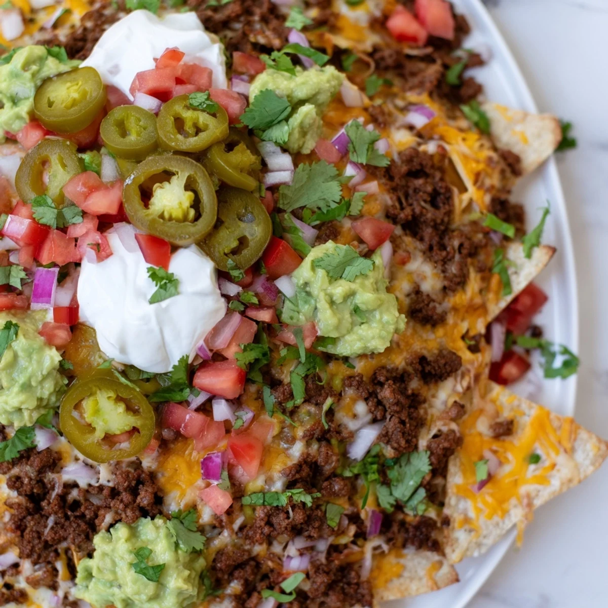 Golden Texas Nachos piled high with melted cheddar, seasoned beef, and colorful fresh toppings