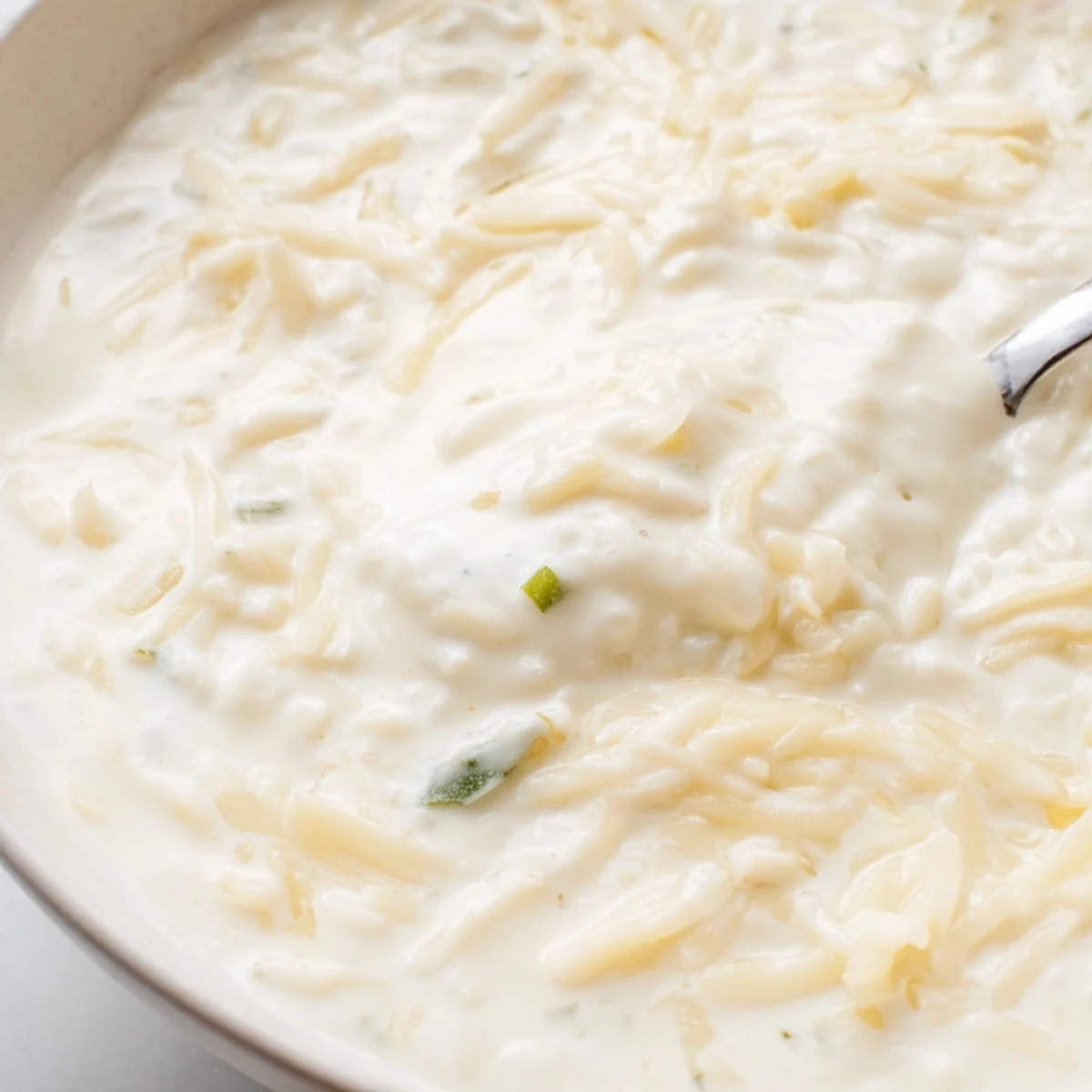 Smooth white queso dip topped with green chilies and onions, perfect for party appetizers