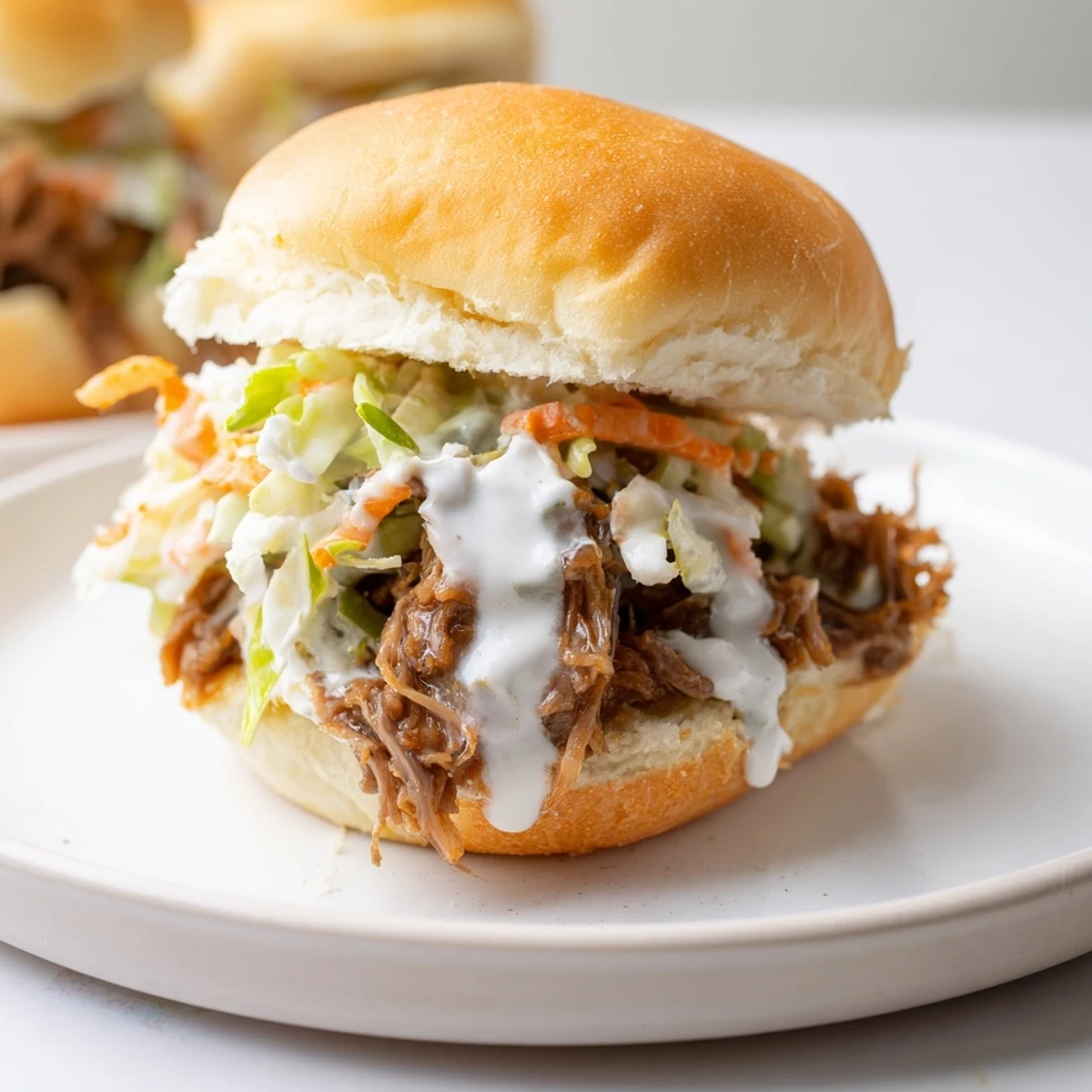 Juicy Alabama white sauce pulled lamb sliders piled high with creamy crunchy slaw