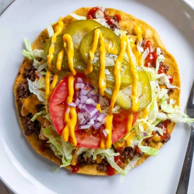 Golden flour tortillas cradling juicy smashed beef topped with fresh lettuce and pickles