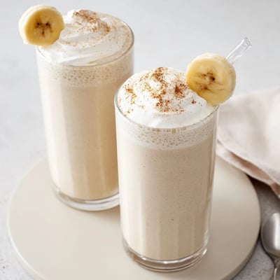 Chilled Vanilla Banana Shake topped with whipped cream and banana slices